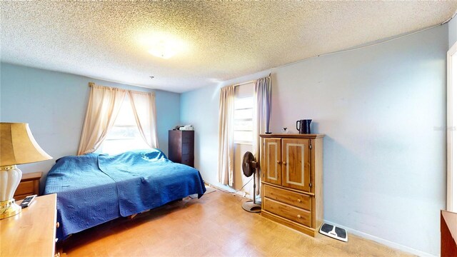 bedroom featuring multiple windows and a textured ceiling