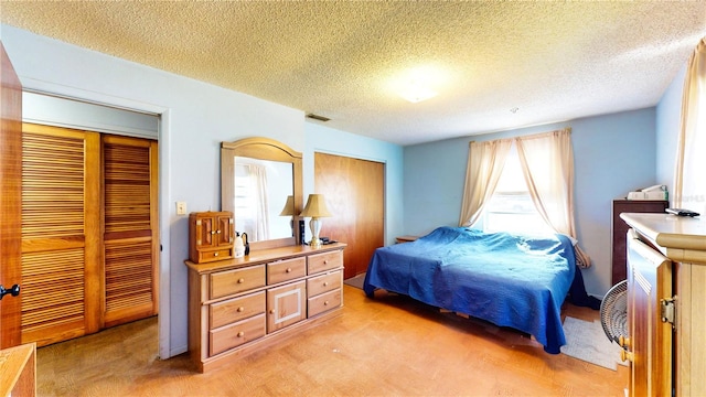 bedroom with a textured ceiling, light carpet, and multiple windows