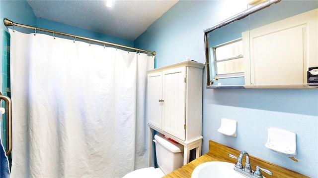 bathroom featuring toilet, sink, a shower with shower curtain, and a textured ceiling