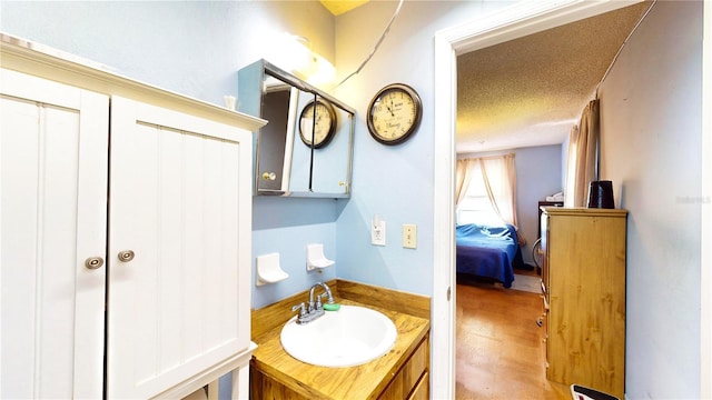 bathroom featuring hardwood / wood-style floors, vanity, and a textured ceiling