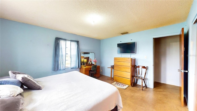 carpeted bedroom featuring a textured ceiling