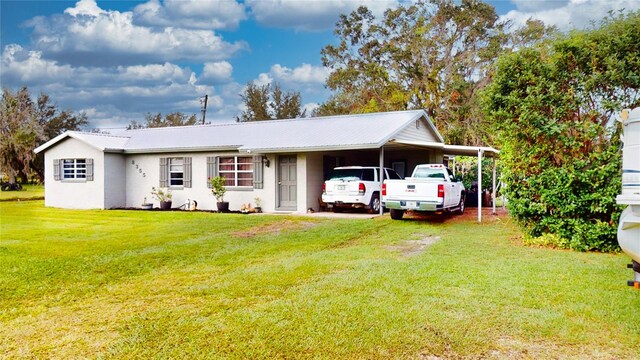 view of front of property with a front yard and a carport