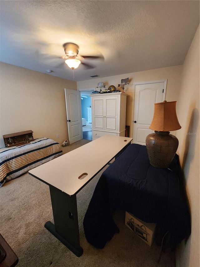 bedroom featuring ceiling fan, a textured ceiling, and carpet floors