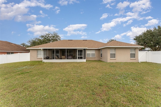 back of property featuring a sunroom and a yard