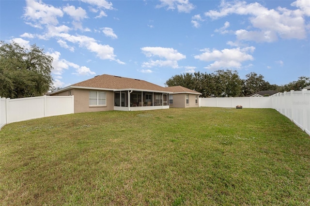 rear view of house with a sunroom and a yard