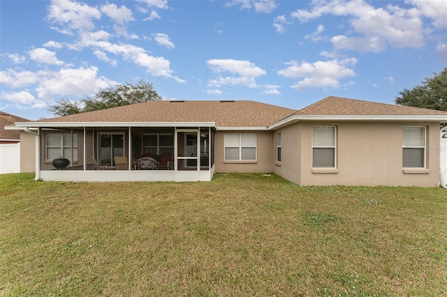 rear view of property with a sunroom and a lawn