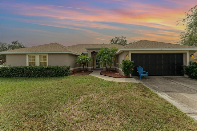 ranch-style home with a yard and a garage