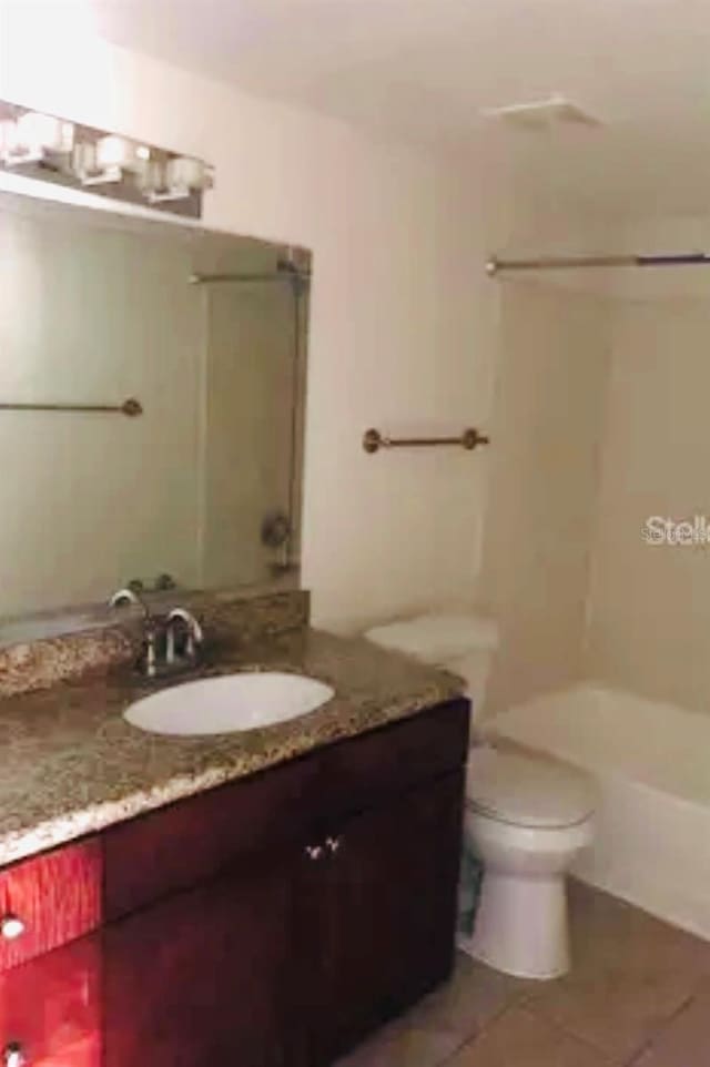 bathroom with tile patterned flooring, vanity, and toilet