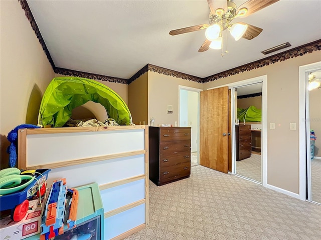 carpeted bedroom featuring ceiling fan and a closet