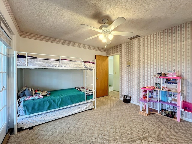 bedroom featuring a textured ceiling, carpet flooring, ornamental molding, and ceiling fan