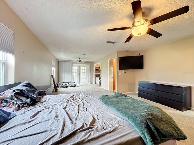 carpeted bedroom featuring a textured ceiling, ceiling fan, and french doors