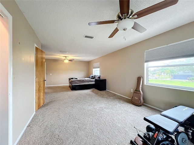 carpeted bedroom with a textured ceiling and ceiling fan