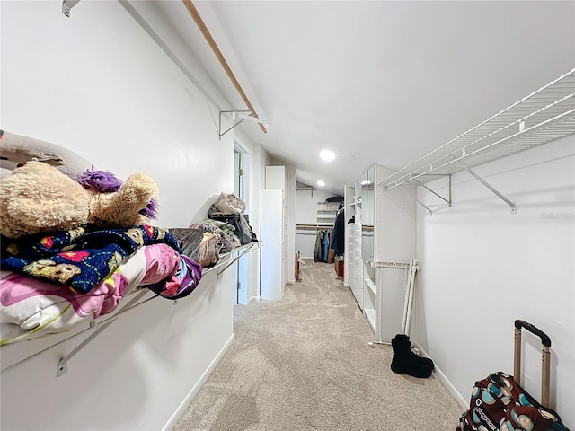 walk in closet featuring vaulted ceiling and light carpet