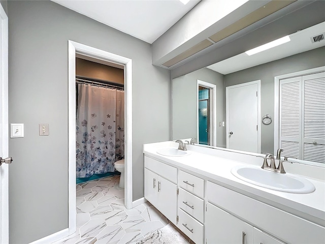 bathroom with walk in shower, vanity, and toilet