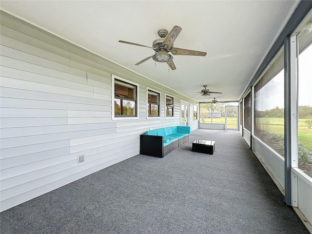 unfurnished sunroom with ceiling fan