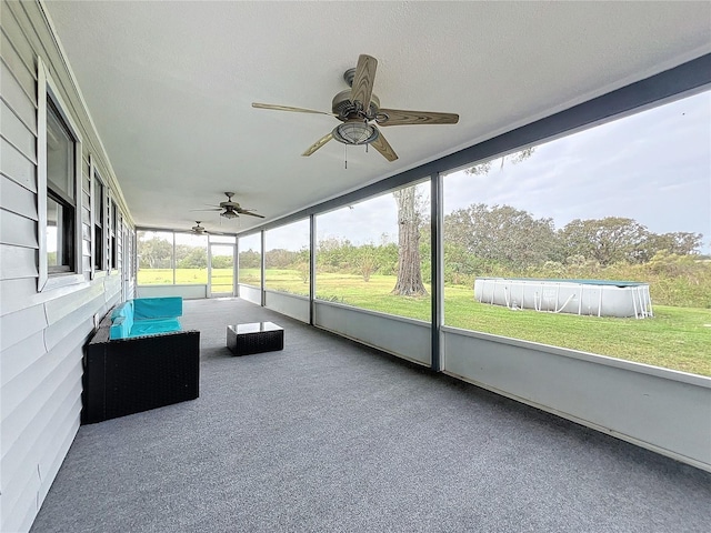 unfurnished sunroom featuring ceiling fan