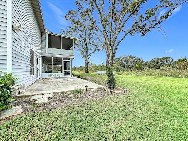 view of yard with ceiling fan, a patio, and a sunroom