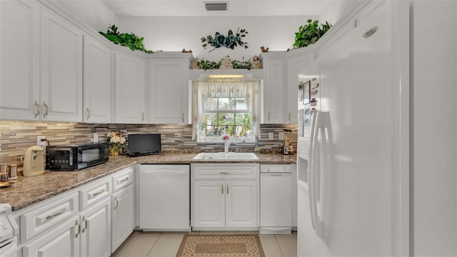 kitchen with white cabinets, decorative backsplash, light tile patterned floors, and white appliances