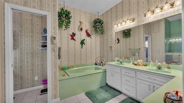 bathroom with a bathing tub, vanity, and tile patterned floors