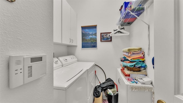 laundry room featuring cabinets and washer and dryer