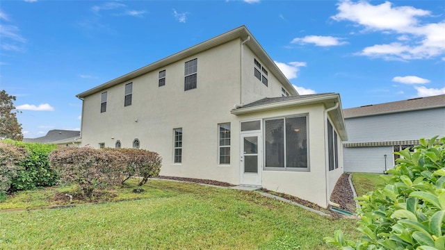 rear view of property featuring a lawn