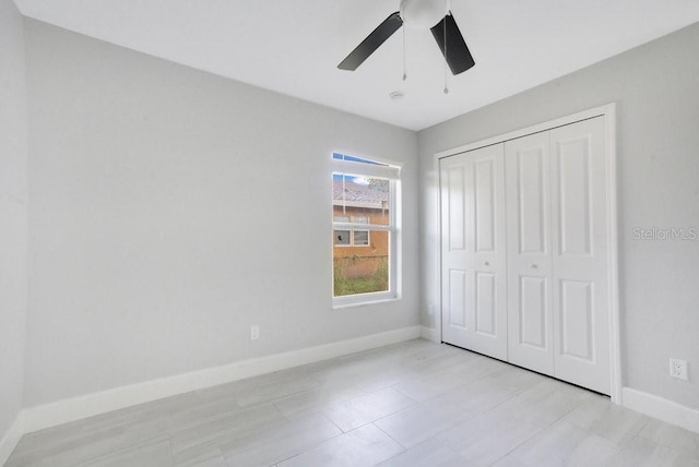 unfurnished bedroom with ceiling fan and a closet