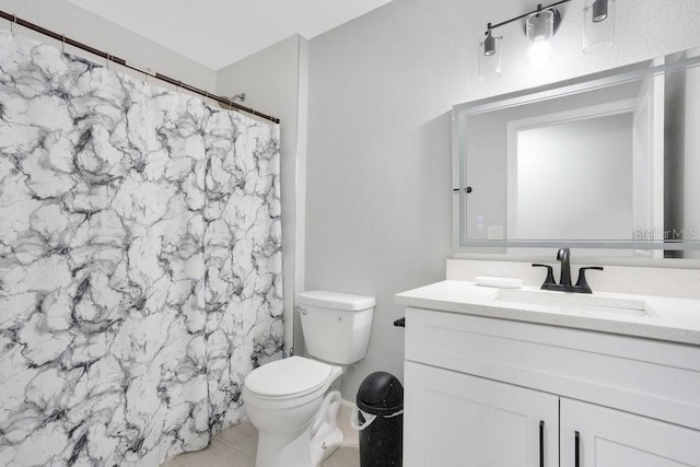 bathroom featuring toilet, vanity, and curtained shower