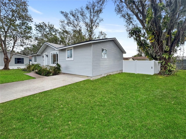 ranch-style house featuring a front yard, fence, and driveway