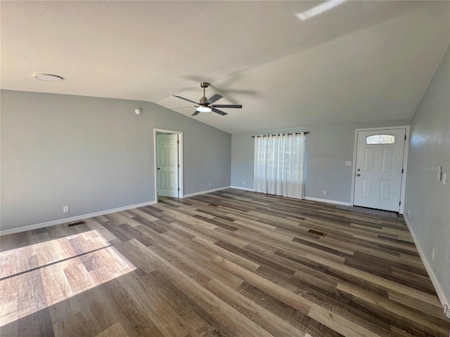 unfurnished living room featuring dark hardwood / wood-style floors, ceiling fan, and vaulted ceiling