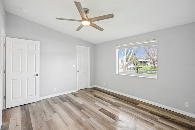 spare room featuring ceiling fan, light hardwood / wood-style floors, and vaulted ceiling