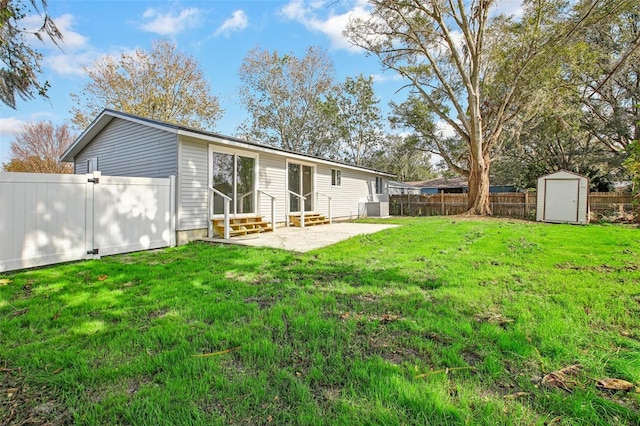 back of house featuring a patio area, a yard, and a storage shed