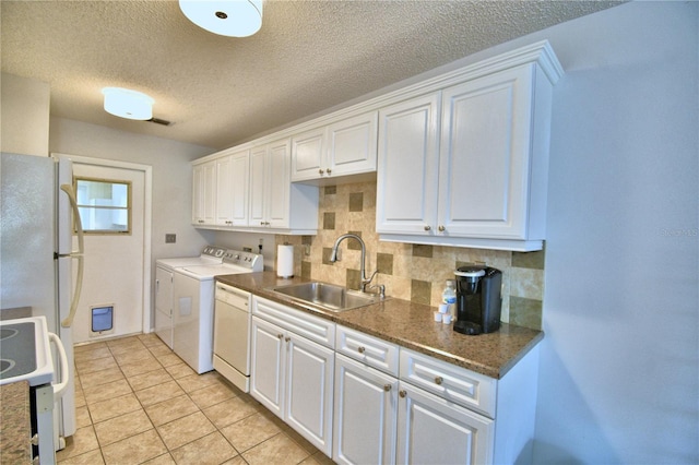 kitchen featuring separate washer and dryer, sink, white appliances, white cabinets, and decorative backsplash