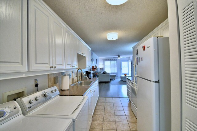 laundry room featuring separate washer and dryer, a textured ceiling, sink, light tile patterned floors, and ceiling fan