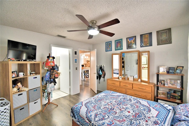 bedroom featuring a textured ceiling, hardwood / wood-style flooring, and ceiling fan