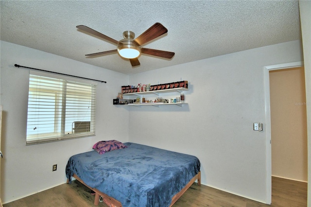 bedroom featuring a textured ceiling, dark wood-type flooring, and ceiling fan