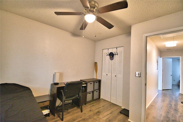 home office with wood-type flooring, ceiling fan, and a textured ceiling