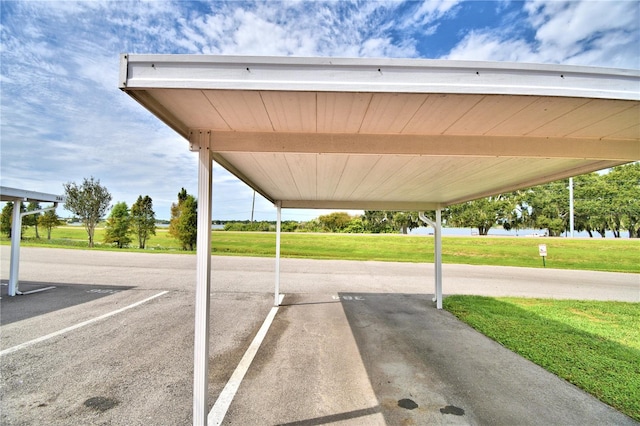 view of vehicle parking featuring a yard and a carport