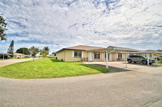 view of front of house featuring a carport and a front lawn