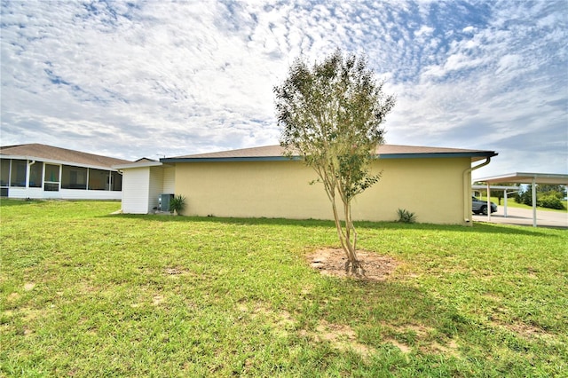 view of side of home with a sunroom, a yard, and cooling unit