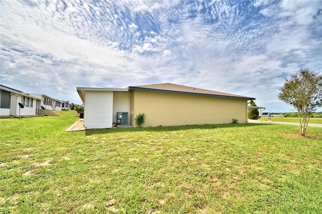 view of home's exterior with central AC unit and a yard