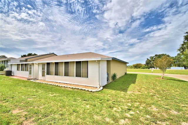 view of home's exterior featuring central AC unit and a yard