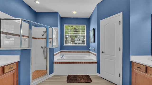 bathroom with hardwood / wood-style floors, vanity, and independent shower and bath