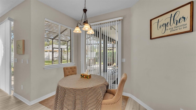 dining area featuring light hardwood / wood-style flooring and a chandelier