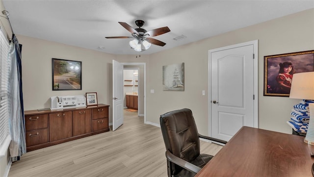 home office with light hardwood / wood-style floors and ceiling fan