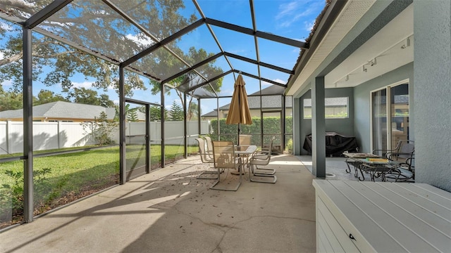 view of patio featuring glass enclosure