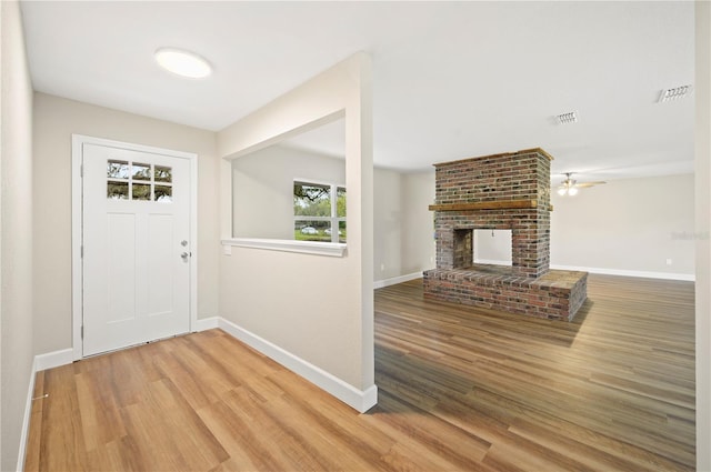 entryway with a fireplace, hardwood / wood-style floors, and ceiling fan