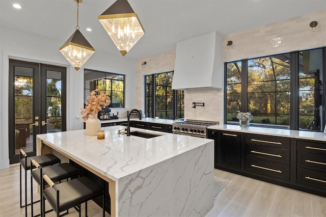 kitchen with plenty of natural light, sink, pendant lighting, and light stone counters