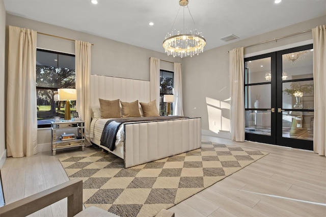 bedroom with french doors, a notable chandelier, and light wood-type flooring