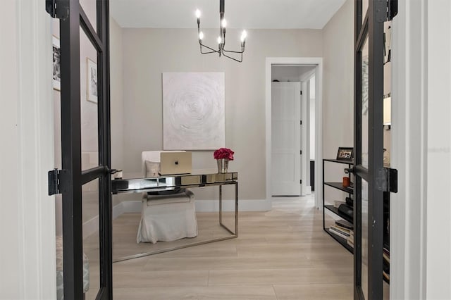 office space with light wood-type flooring and a notable chandelier