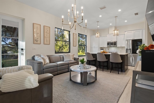 living room featuring sink and an inviting chandelier